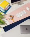 The Minimalist Mat in different on a white background with a key board, mouse and a spilt cup of coffee on it.