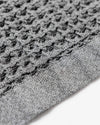 Close up of the Onsen Cinder Grey Bath Sheet on a white background.