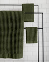 The Onsen Forest Waffle Bath Sheet on a iron towel rack.