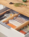 The Open Spaces Drawer Divider inside a drawer separating cooking condiments.