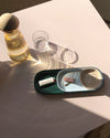Top view of the Open Spaces Dark Green Nesting Tray with keys and other items on a cream background.