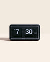 Mid Century Flip Clock in Black on a cream background.