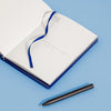 An open The 365 Days of Journal on a blue background next to a pen.