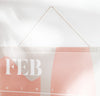Close up of the Acrylic Poster Hanger in Large holding up a wall planner.