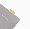 Close up Brass Bookmark Ruler inside a book on a white background.
