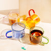 Four different colored Double Wall Mug displayed one filled with tea and one filled with coffee on a white background.