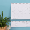 The Stick To It Weekly Pad on a light blue wall.