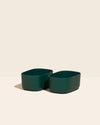 Two Small Dark Green Storages Bins with no lids on a cream background.