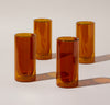 Four 16 oz Amber Double Wall Glasses on a cream background.