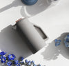 An overhead shot of the Matte Gray Ceramic French Press on a grayish background.