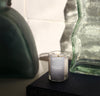 A 2.5 Oz Chamomile candle placed on a black book on a cream background.