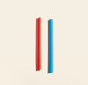 GIR - Two smoothie straws, orange and blue, laid on a backdrop.