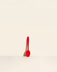 GIR Spoon in Red on a cream background.