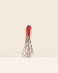 GIR Ultimate Whisk in Red on a cream background.