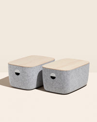 2 Open Spaces Large Felt Storage bins with wooden lids on a cream background.