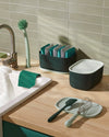 The Dark Green Small Storage Bin with Mint Lid on a wooden surface. 