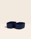 Two Small Navy Storages Bins with no lids on a cream background.