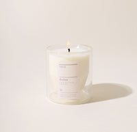 A 6 Oz Aviles Double wall  candle on a cream background. 